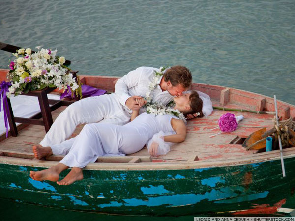 Newly married couple kissing each other on a decorated boat